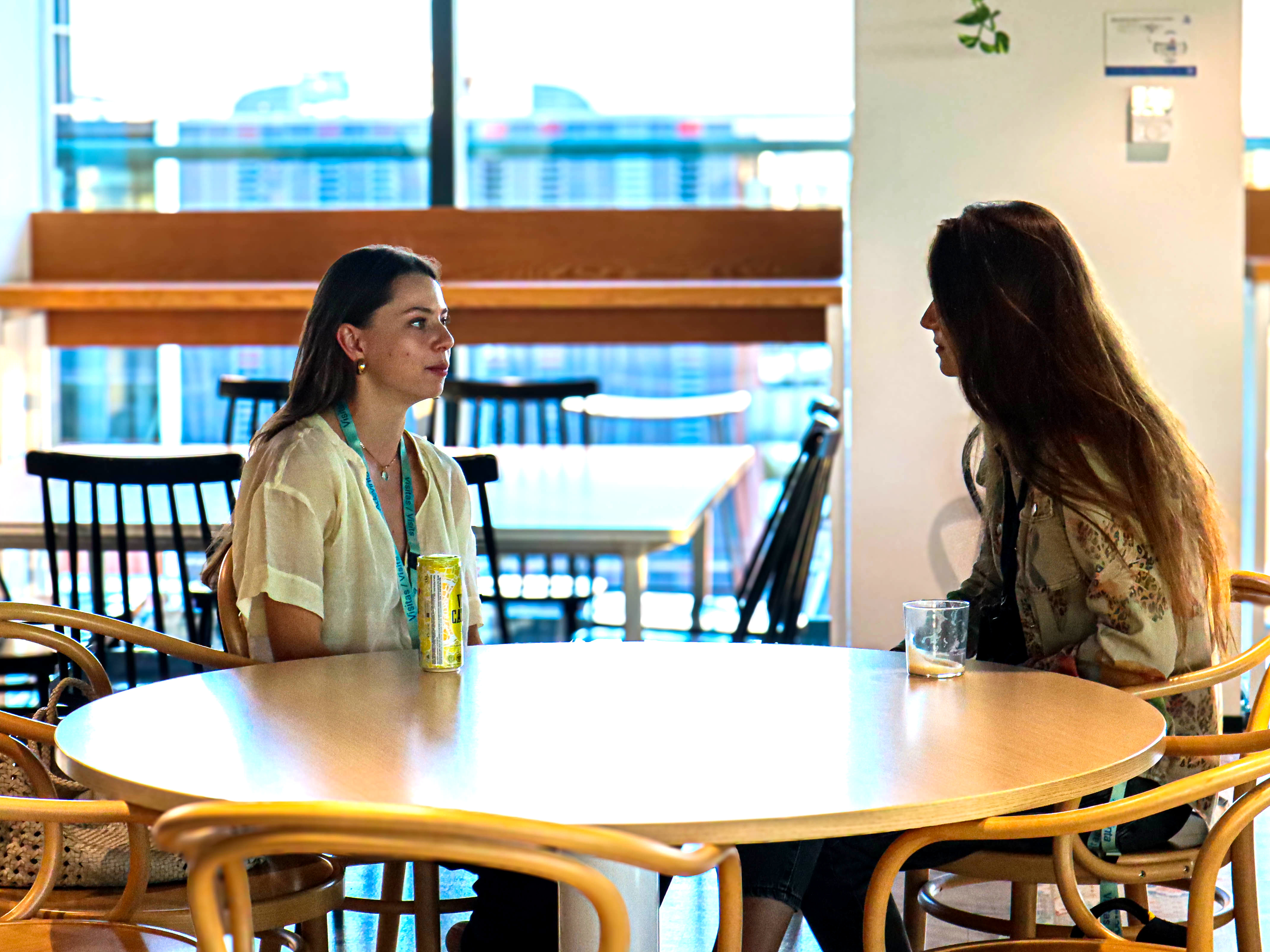 two women sitting at a table talking to each other